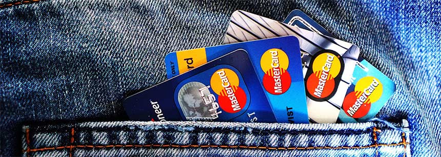 Jeans-Hosentaschen mit mehreren Mastercard-Karten, die die weit verbreitete Akzeptanz von Mastercard zeigen